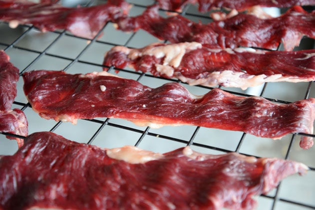 Putting meat strips on baking rack